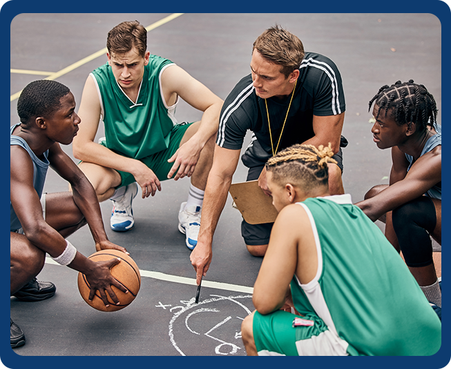 A group of young men sitting on top of a basketball court.