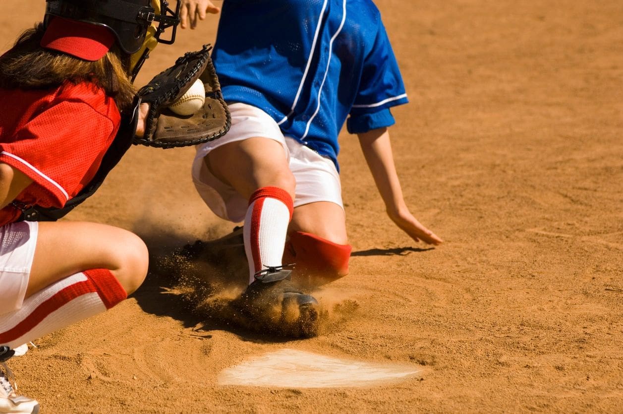 Player sliding into home plate in baseball.