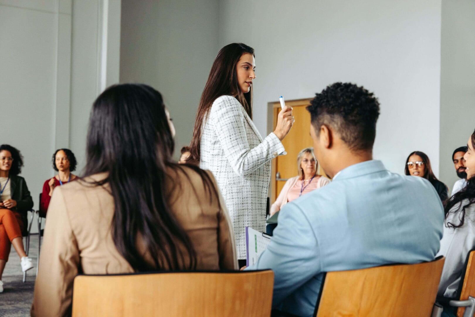 Woman speaking to a seated audience group.