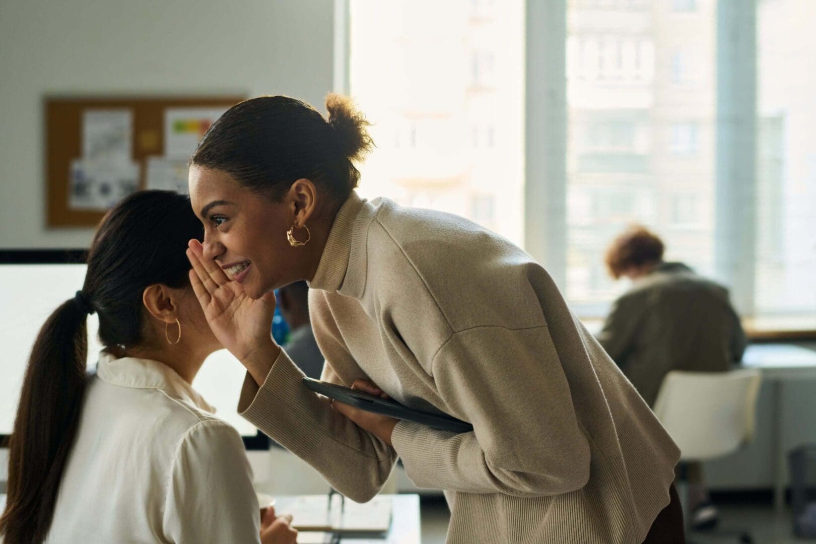 Two women talking in a bright office.