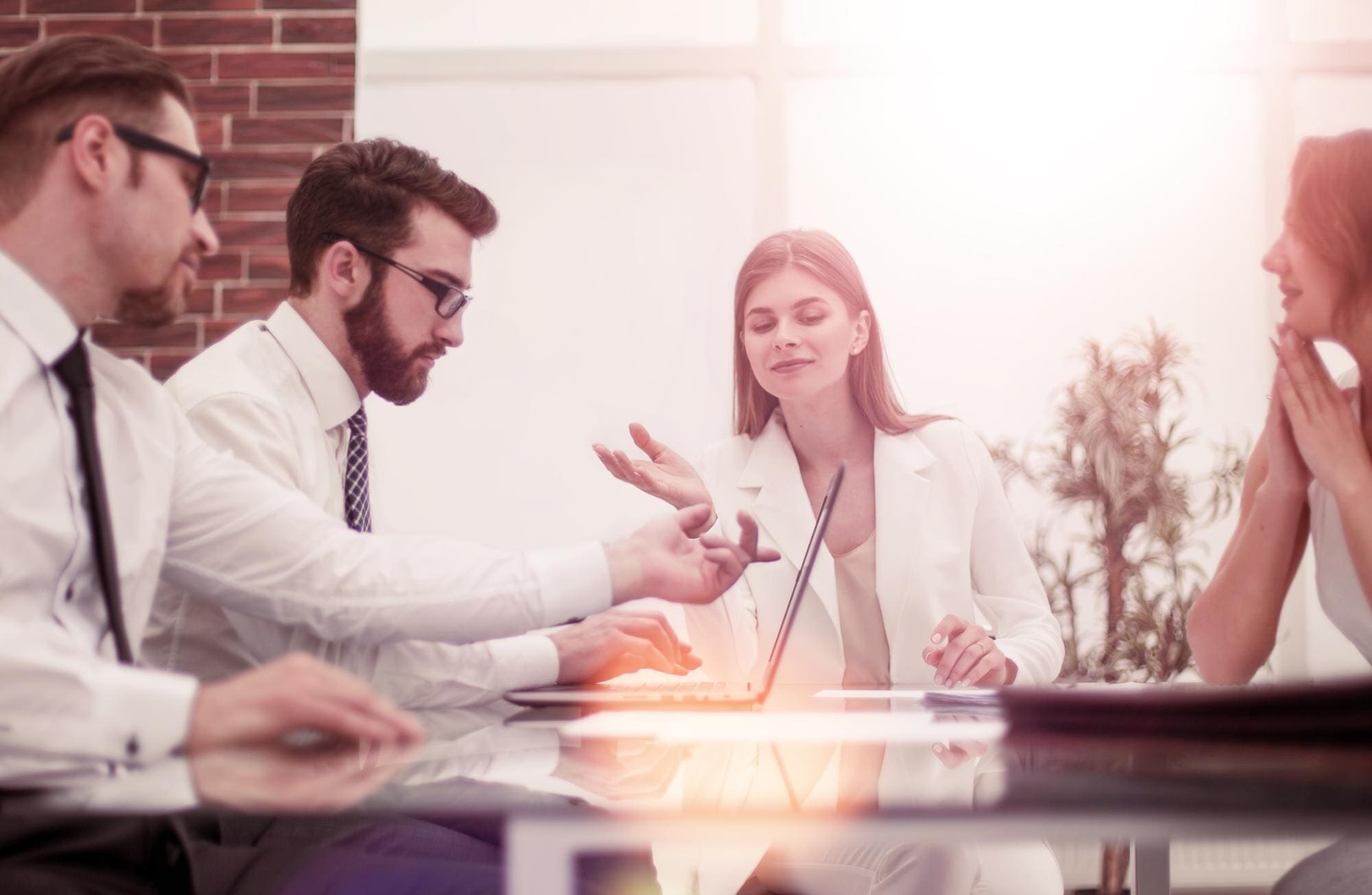 Business meeting with four professionals discussing.