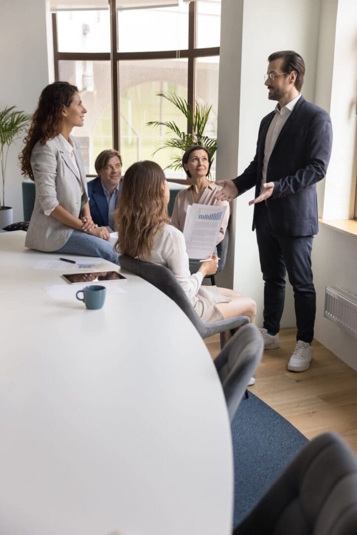 Business meeting with five people discussing.