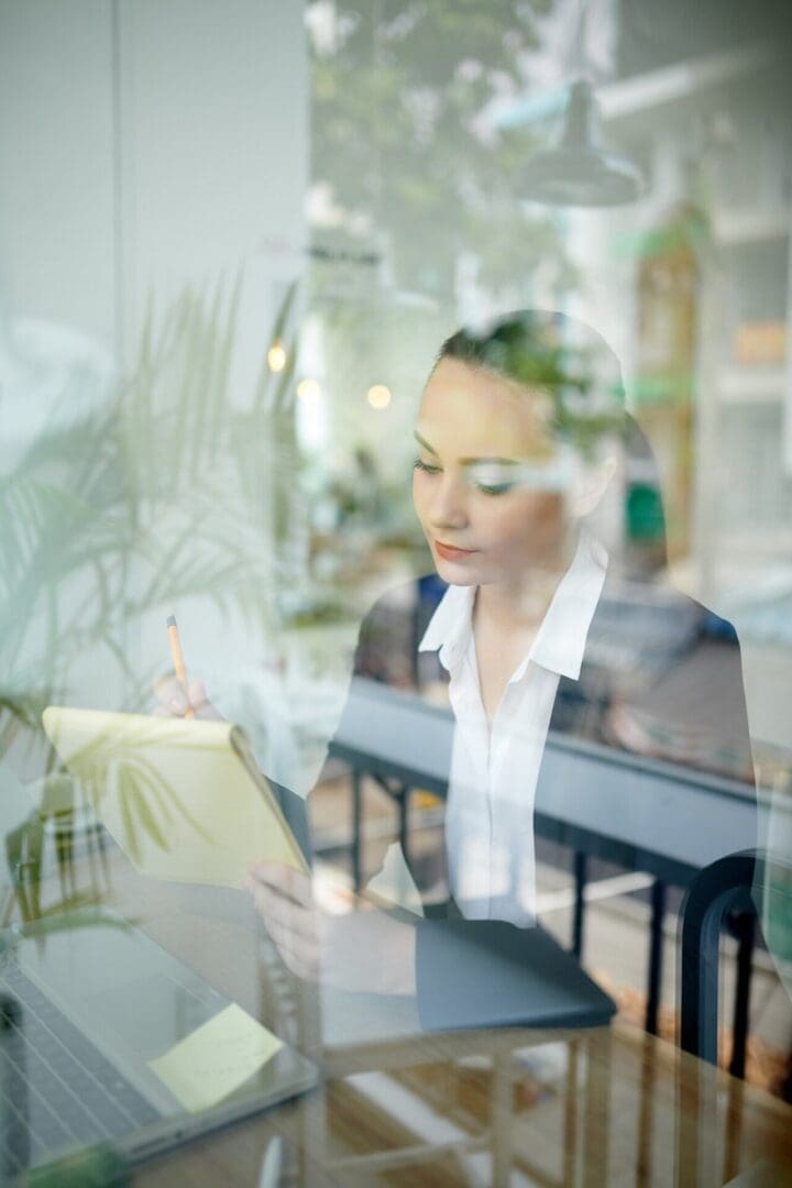 Businesswoman working at desk with reflection.