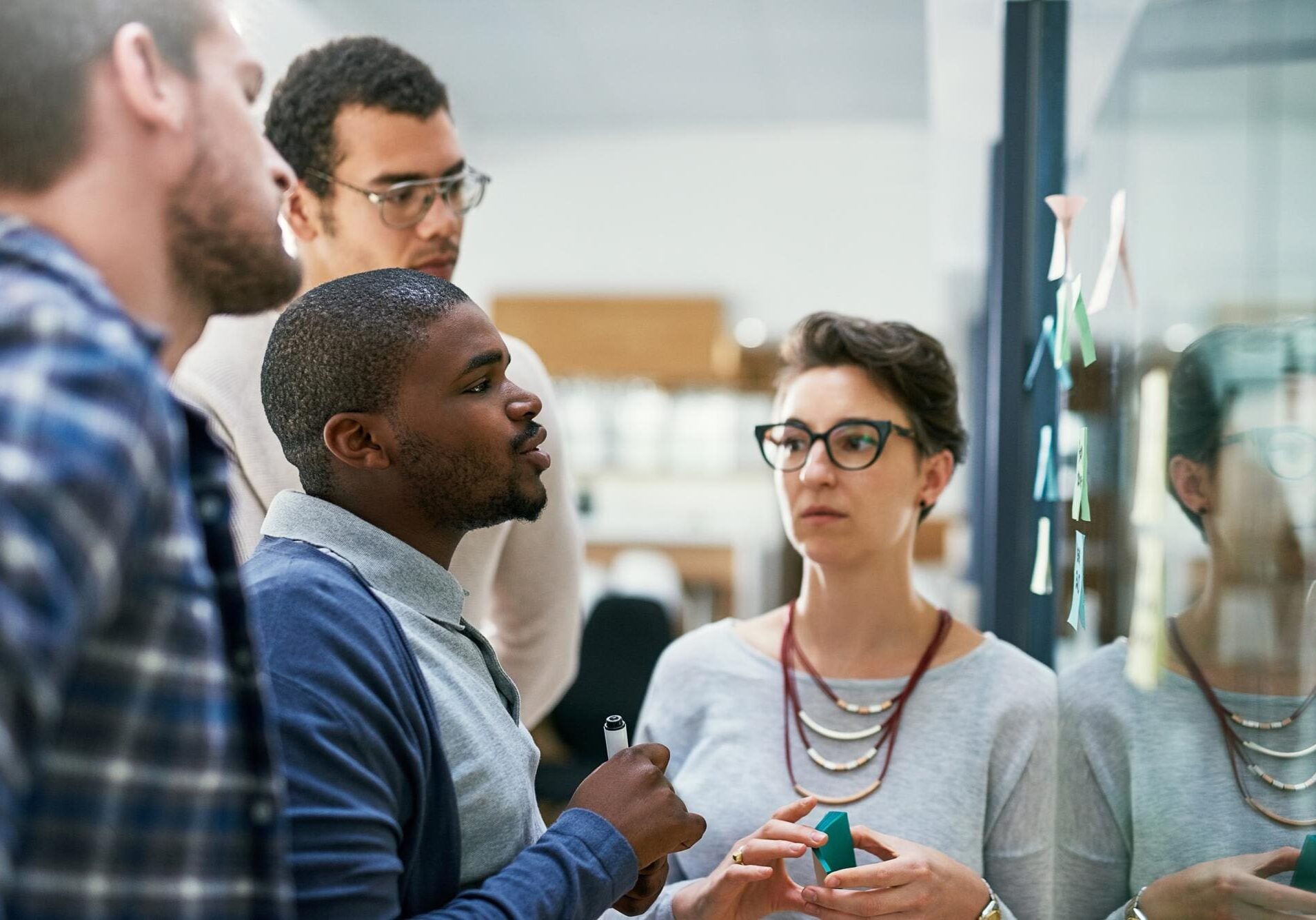 Group brainstorming with sticky notes on board.