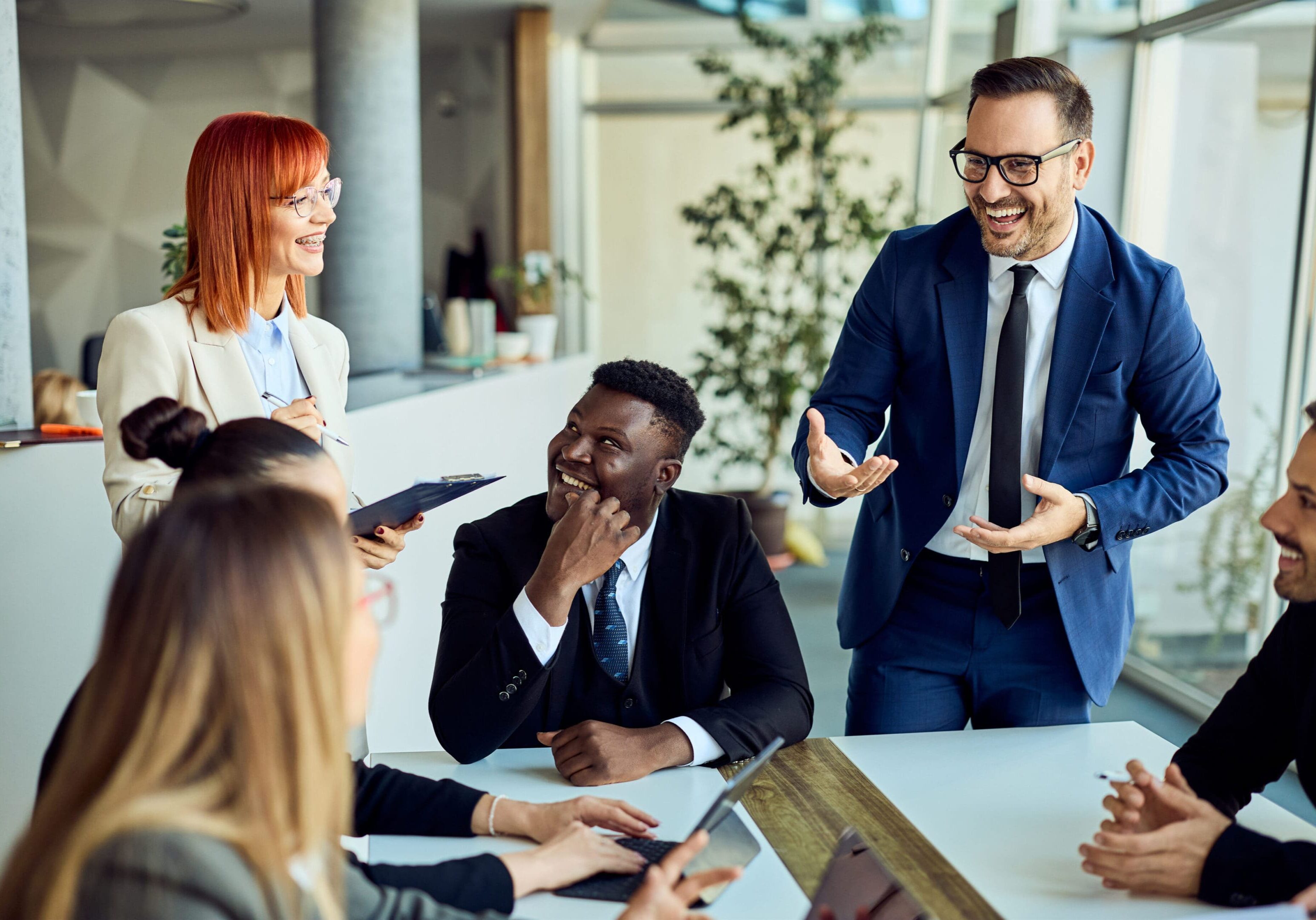 Business meeting with colleagues laughing and discussing.