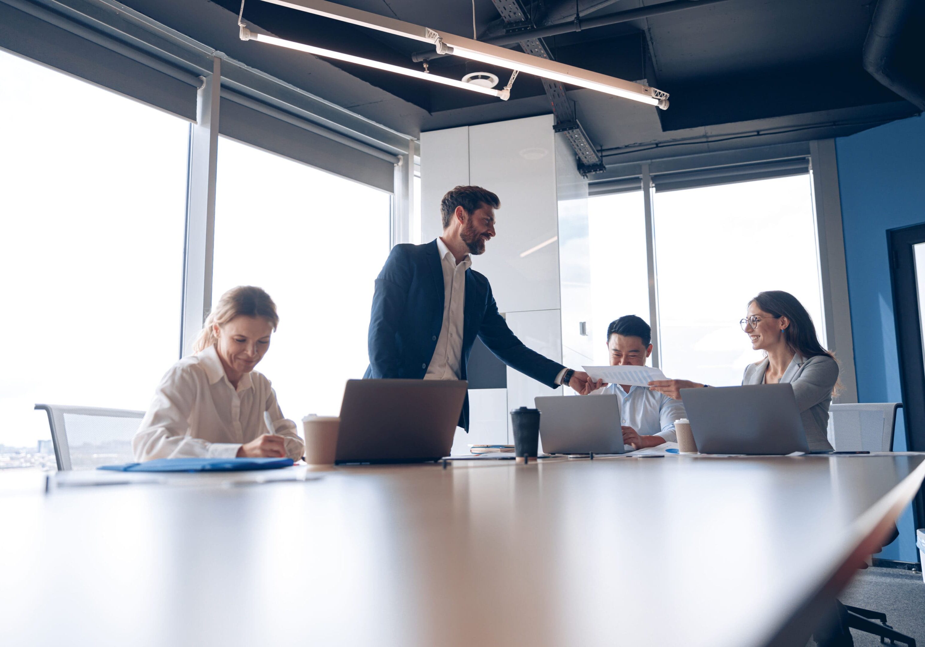 Office meeting with laptops and documents.