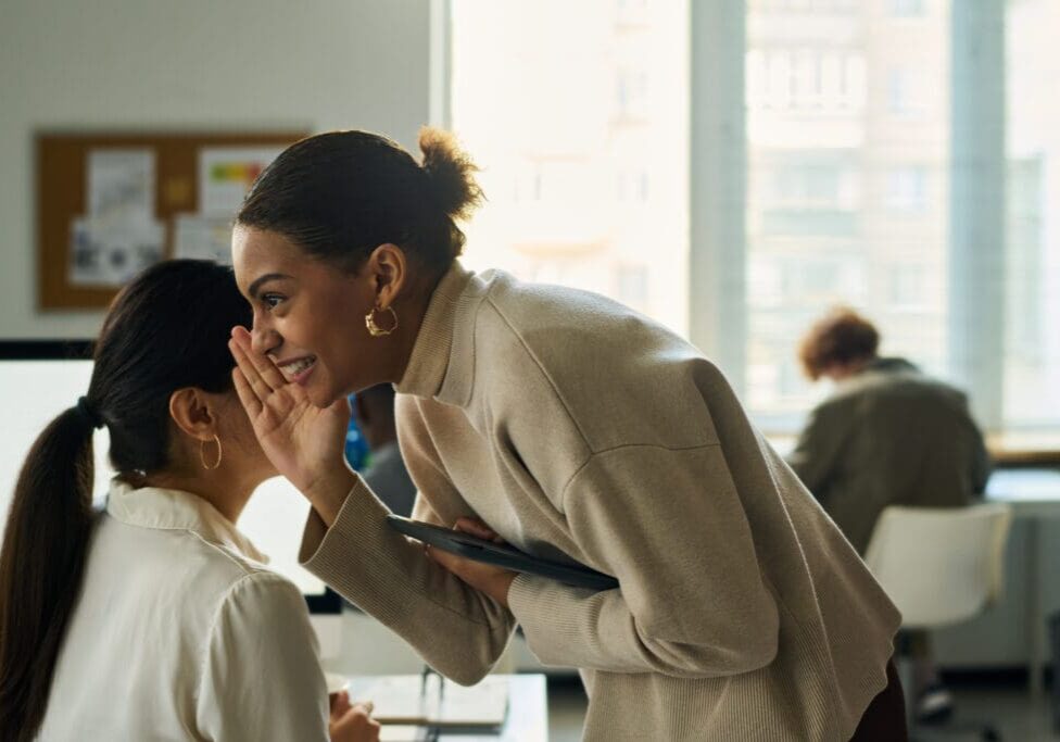 Two women talking in a bright office.