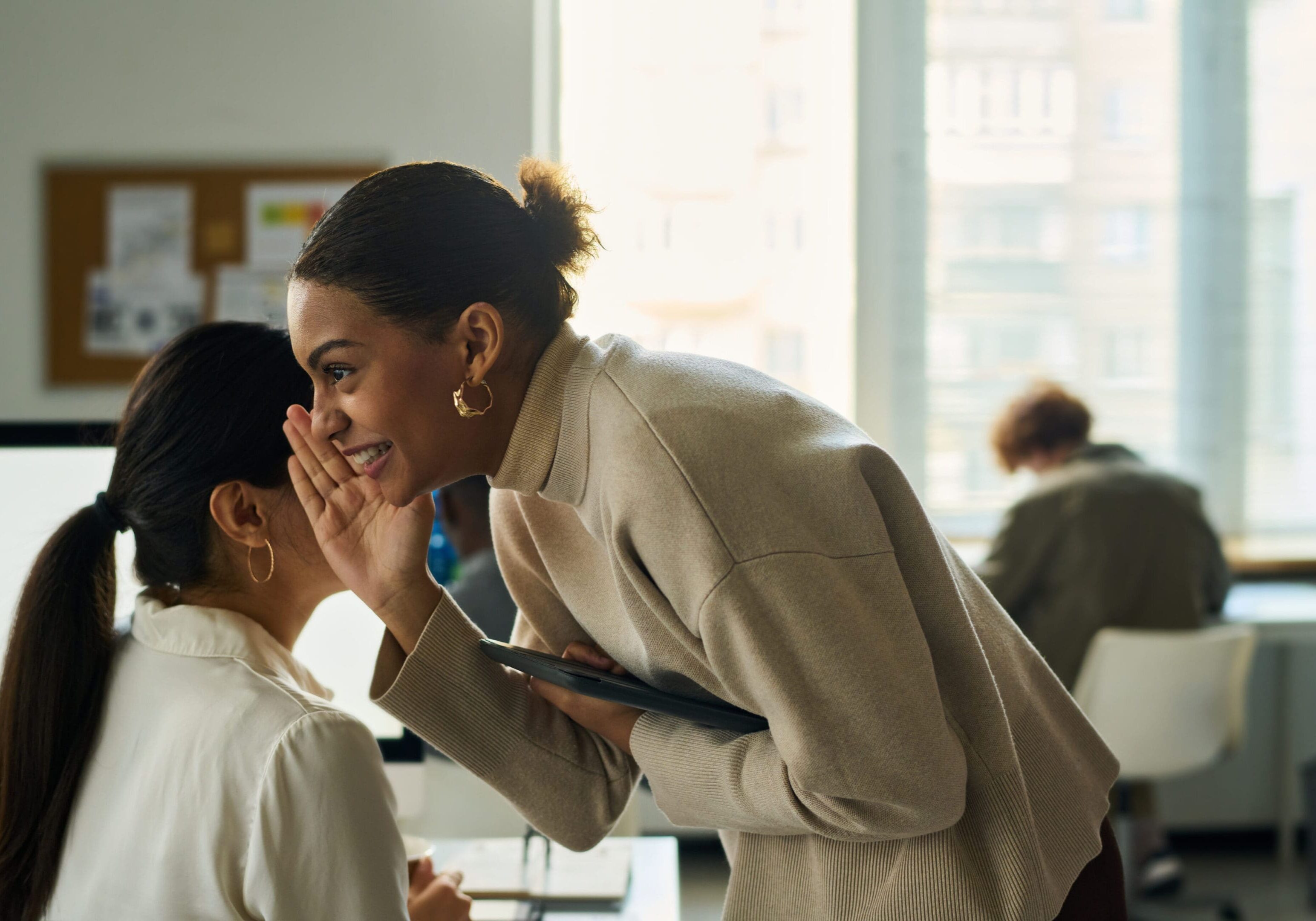 Two women talking in a bright office.