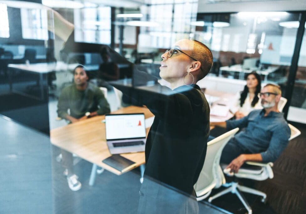 Person presenting to colleagues in office meeting.