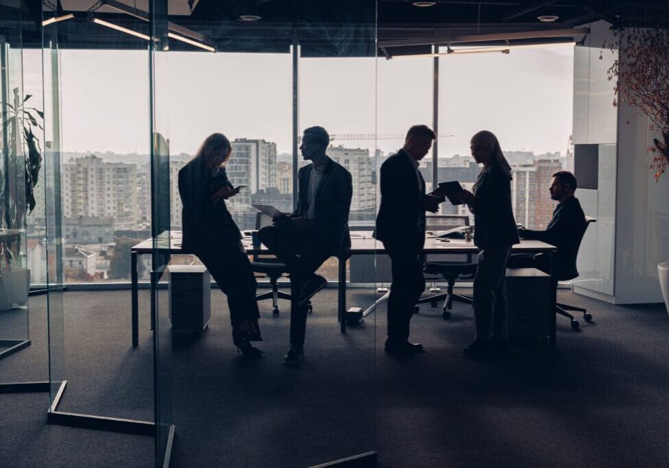 Silhouetted people in a modern office setting.