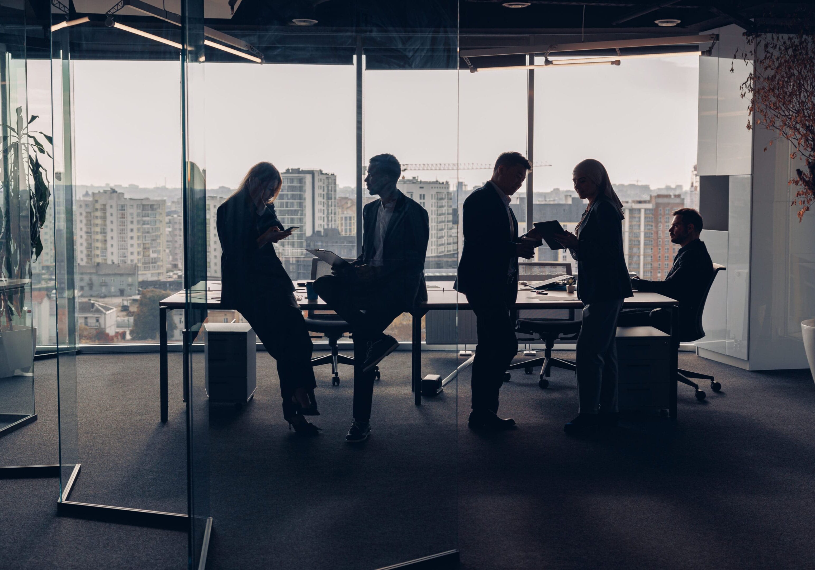 Silhouetted people in a modern office setting.