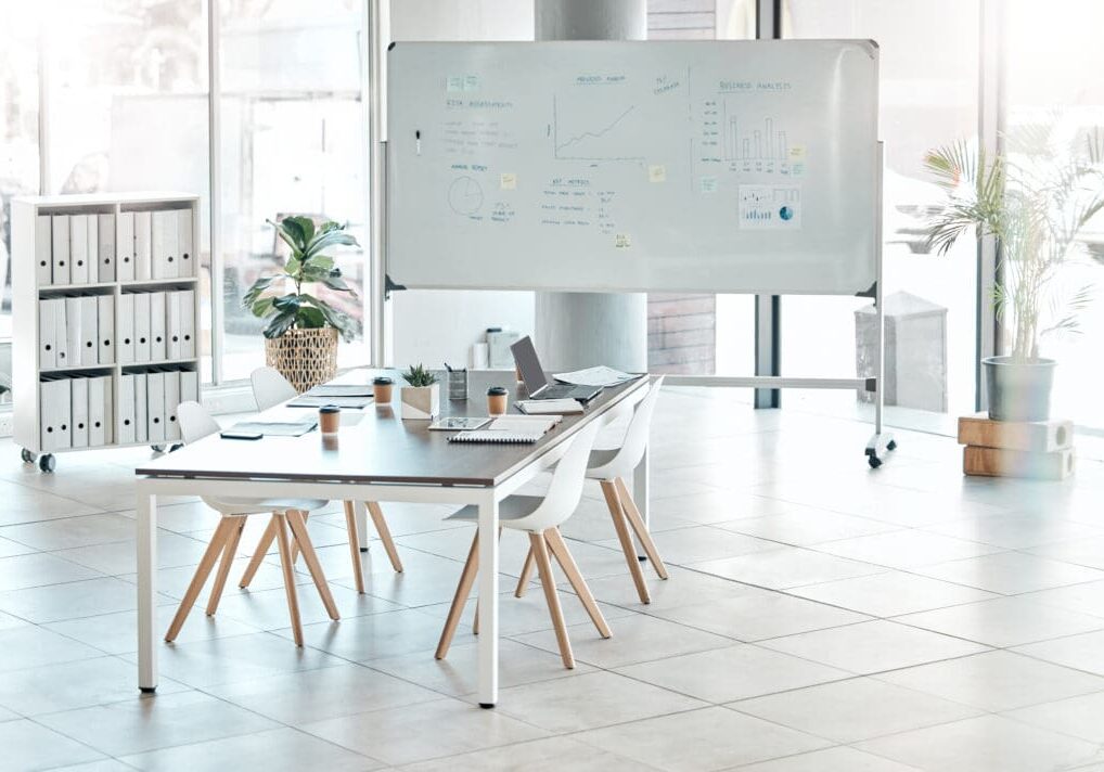Modern office with whiteboard and table setup.