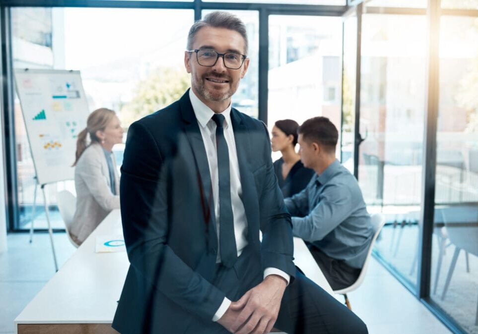 Businessman smiling in modern office setting.
