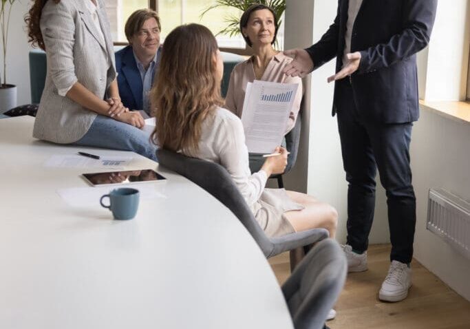 Business meeting with five people discussing.