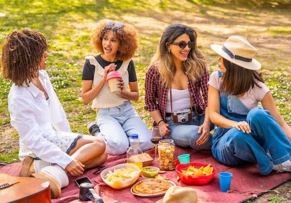 Four friends enjoying a picnic outdoors together.