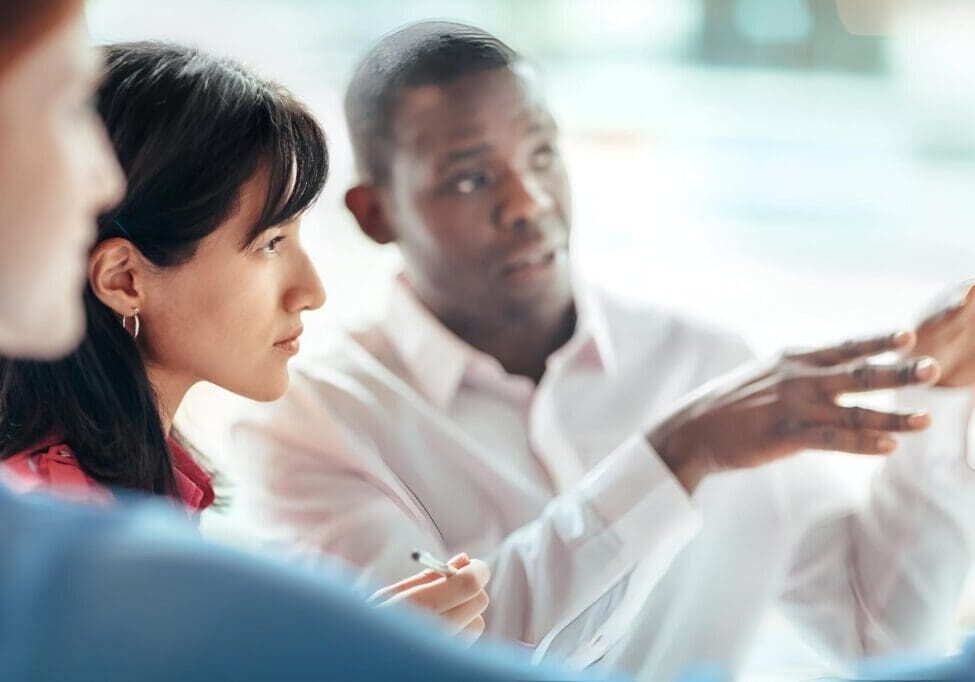 Colleagues discussing work in a meeting.