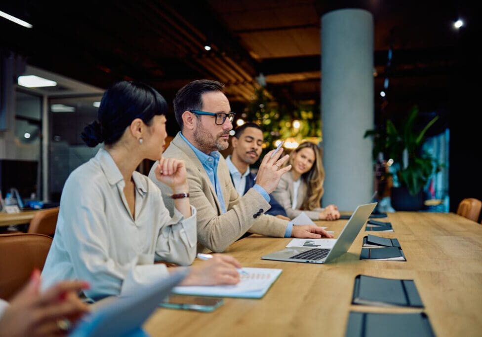 Business meeting with people discussing around table.