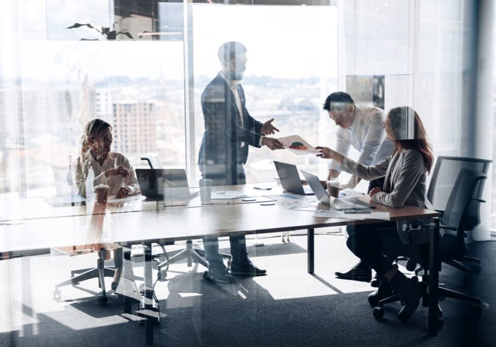 Business meeting in a modern glass office.