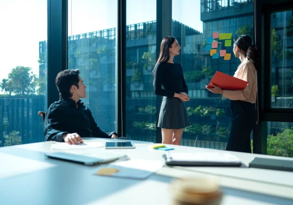 Office meeting with sticky notes on window.