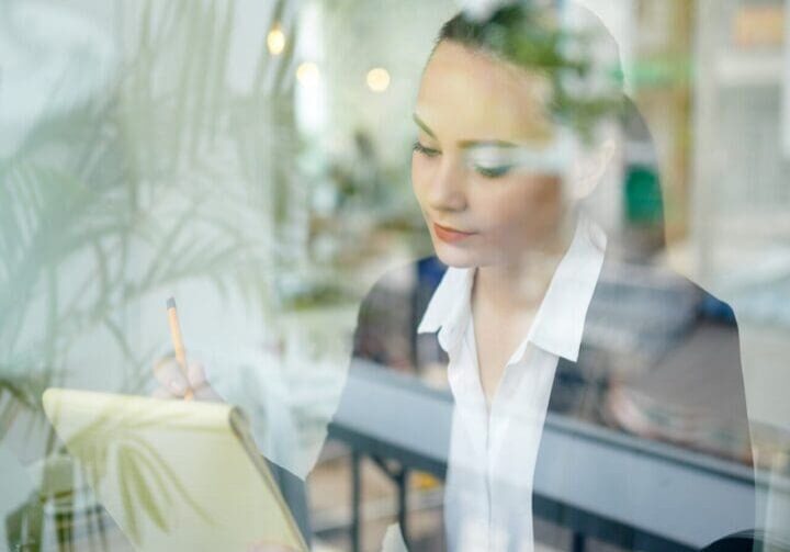 Businesswoman working at desk with reflection.
