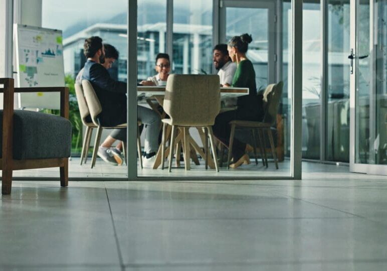 Business people, team and meeting with blur in conference for planning, brainstorming or strategy. Group, employees or colleagues with discussion for analytics, statistics or performance in workplace