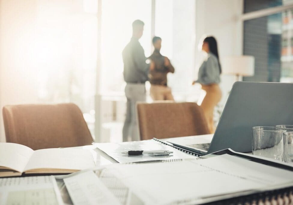 Desk, paperwork and notebook with laptop in office, professional workspace and setup, folder and planning. Strategy, documents and research, busy with business proposal with meeting and information