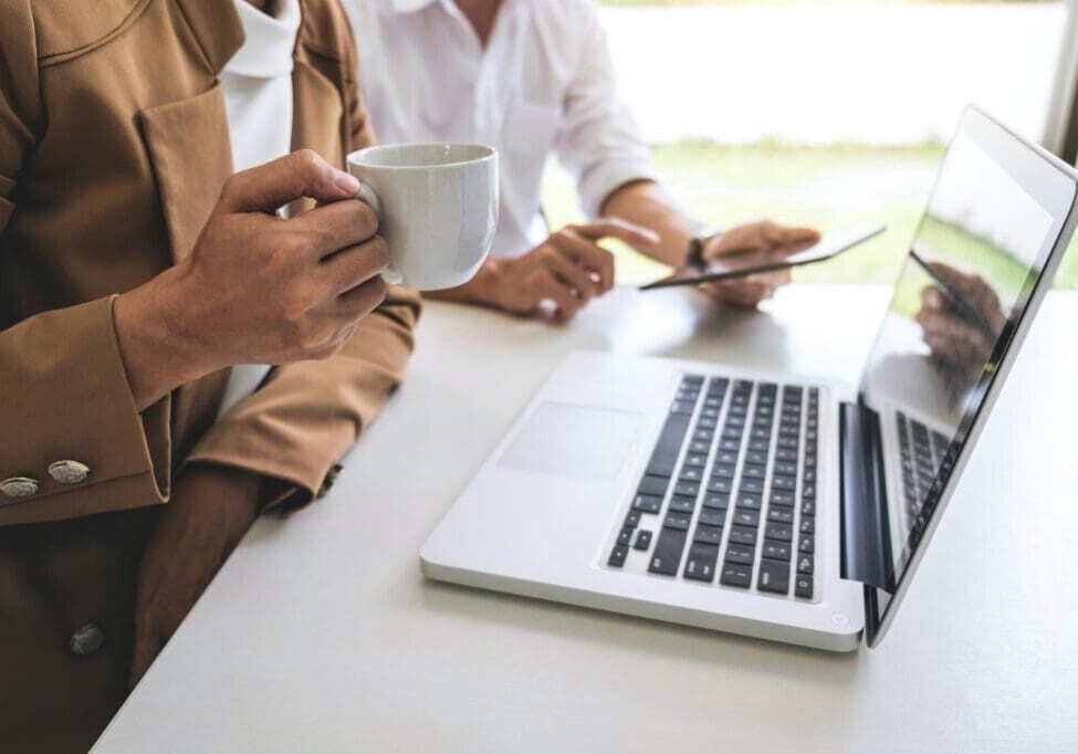 Colleagues working with laptop and coffee