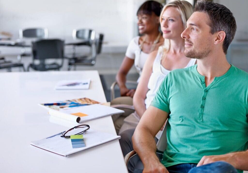 Adults seated at table attentively listening