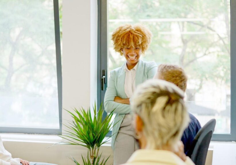 Smiling woman leading a casual office meeting
