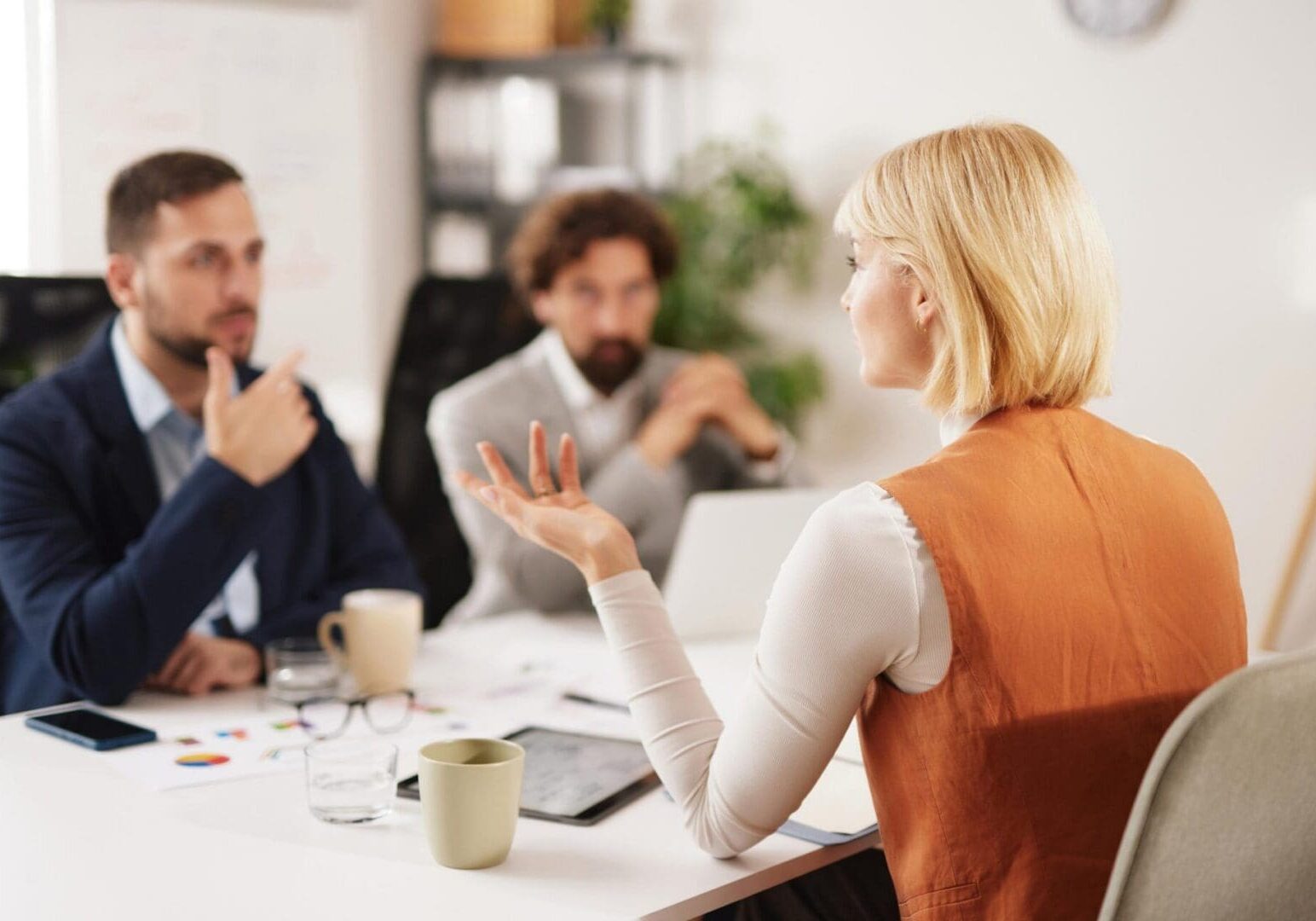 Woman speaking to colleagues during office meeting