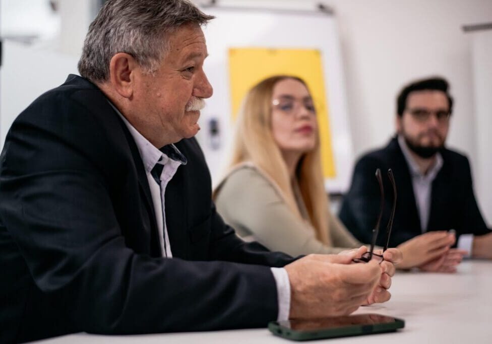 Man holding glasses during business meeting