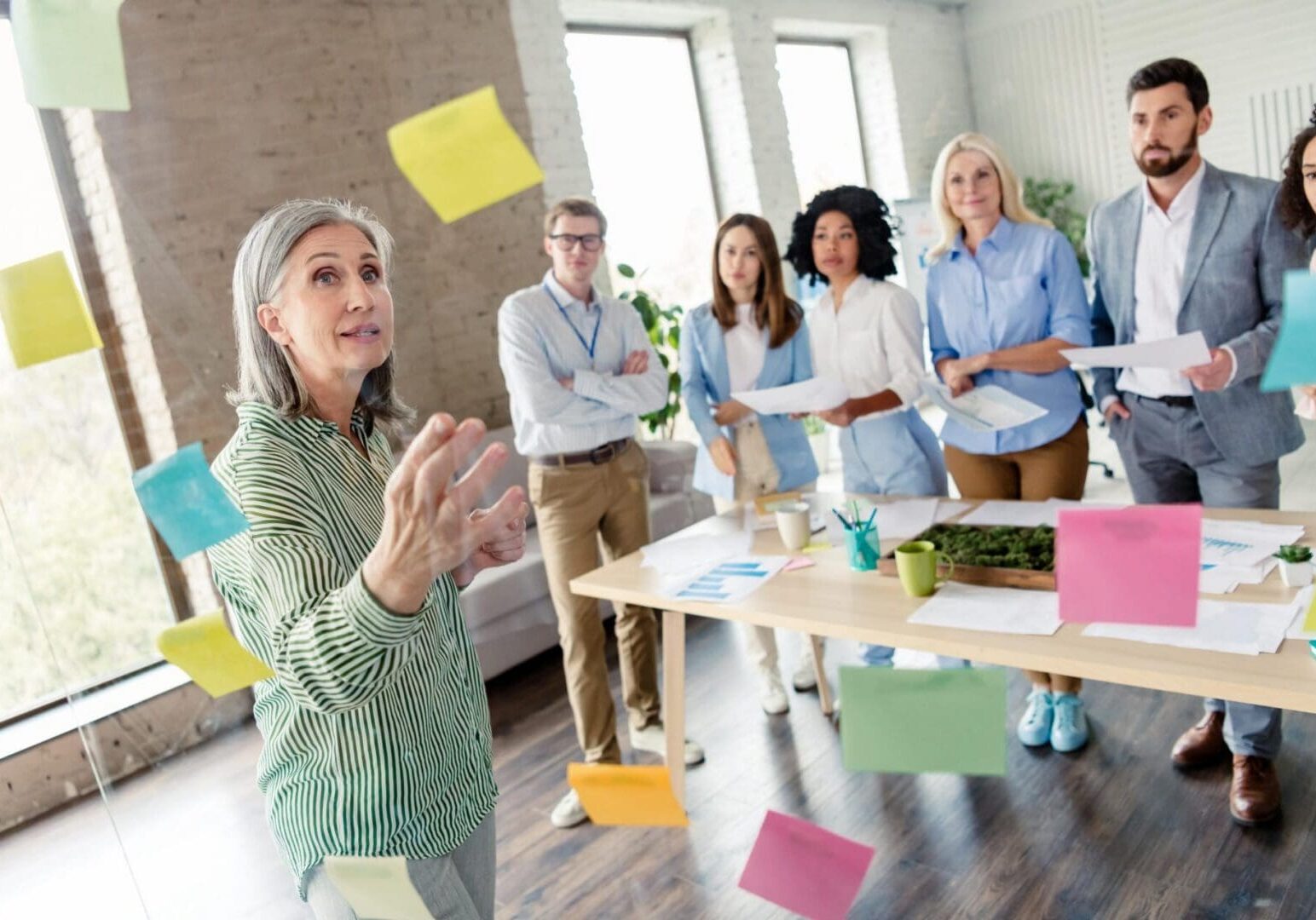 Team meeting with woman presenting sticky notes