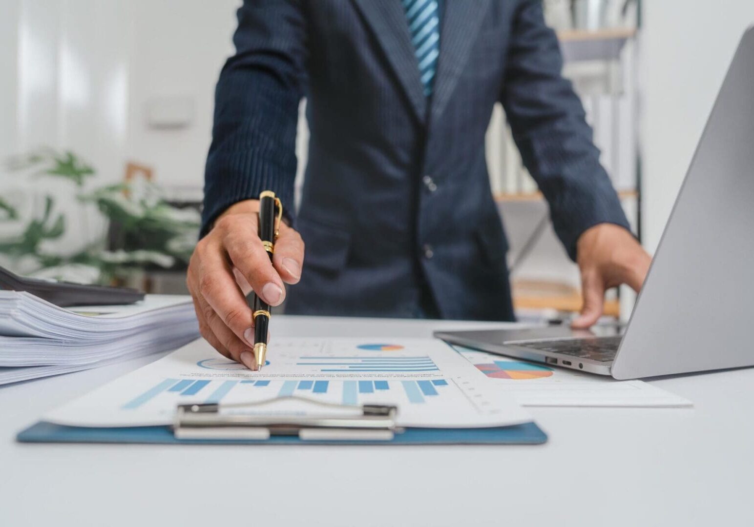 Businessperson pointing at financial charts on desk