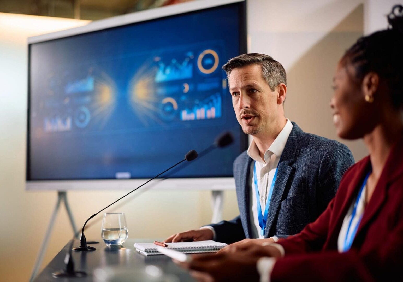Two presenters speaking at conference panel