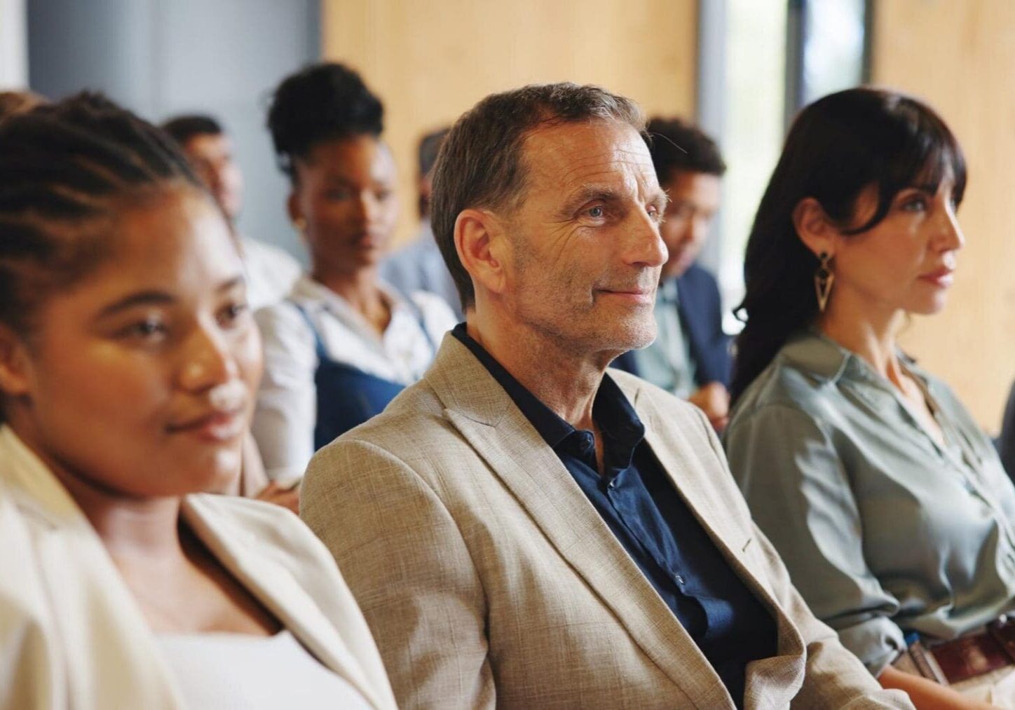 Diverse audience seated, listening attentively