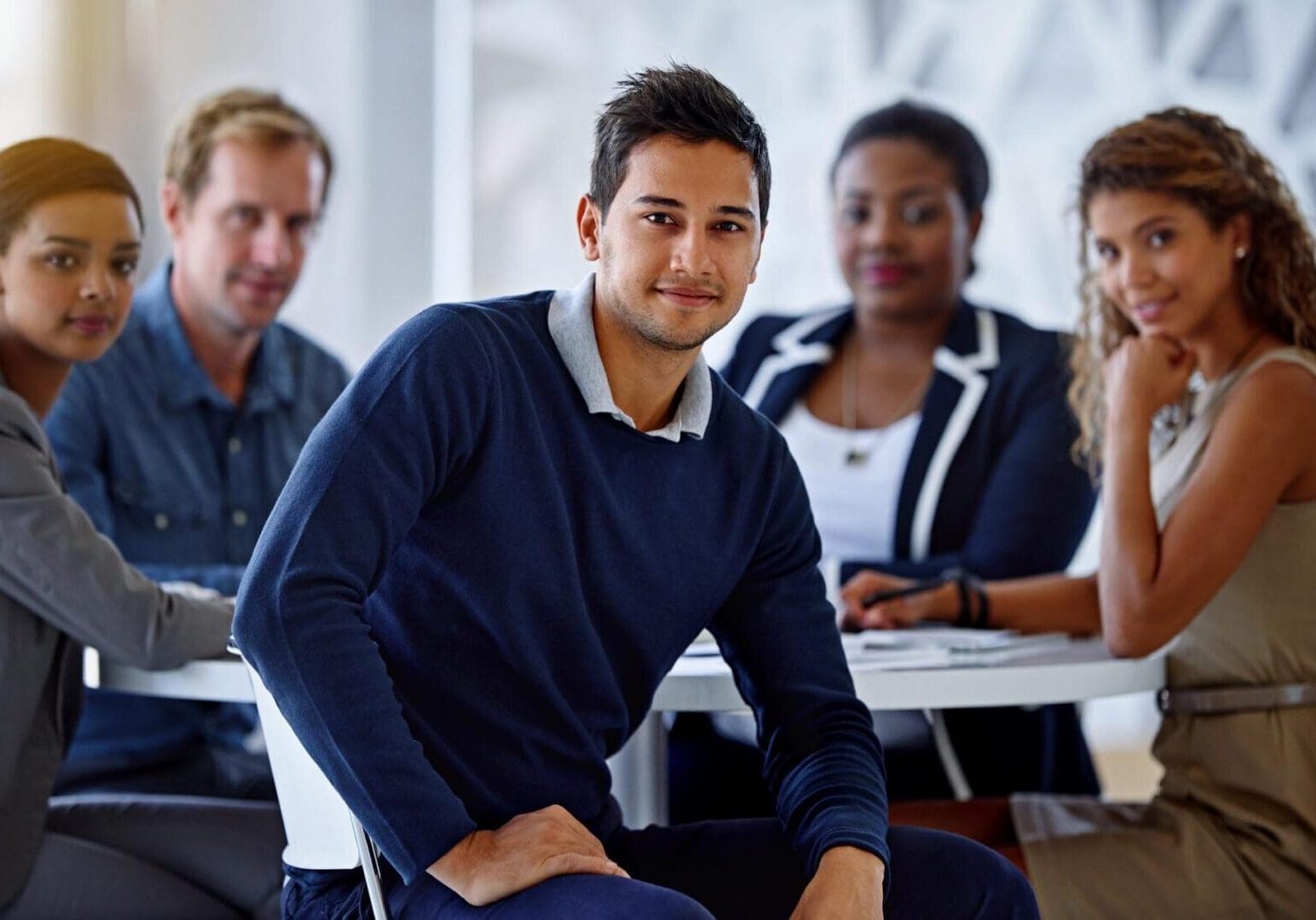 Smiling man with colleagues around table