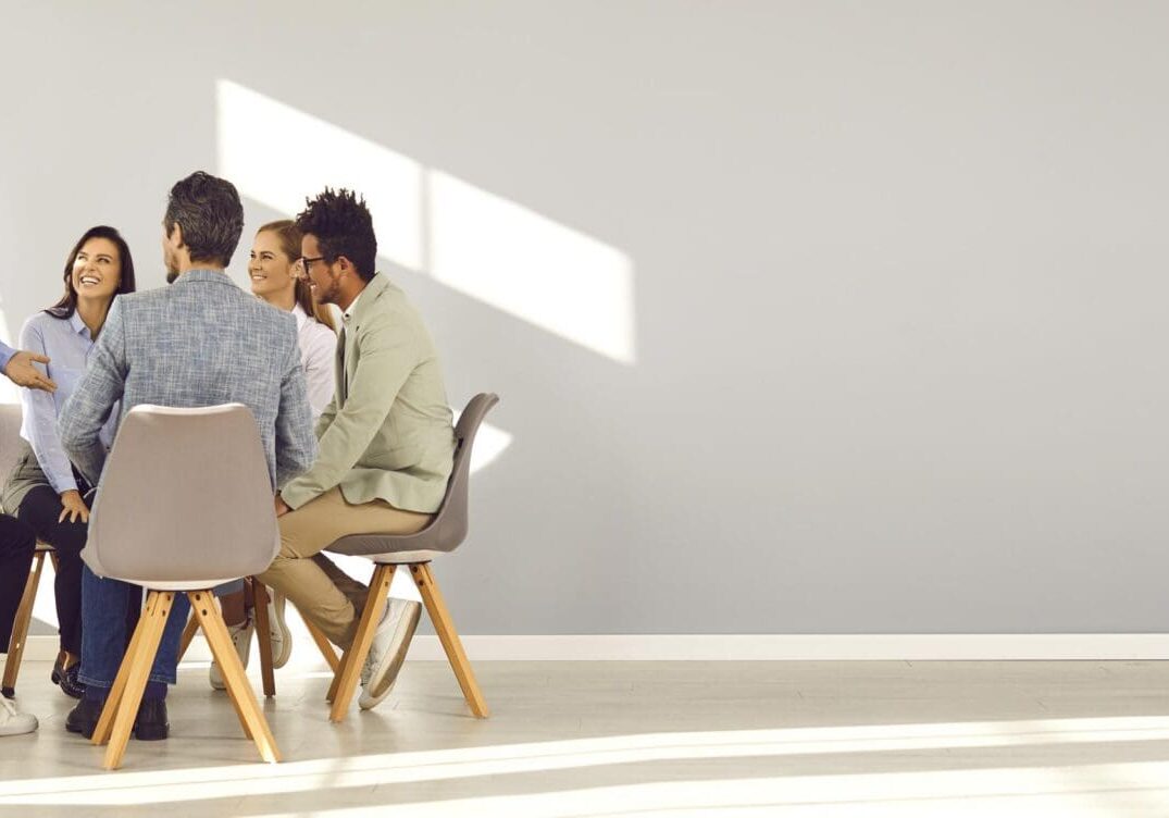Smiling team of six seated in circle