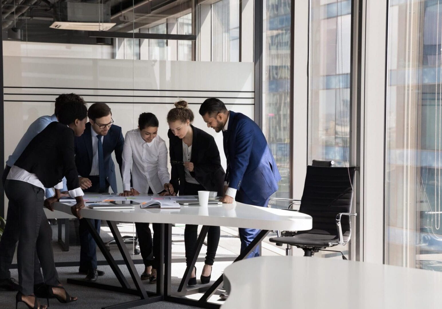 Group of multi ethnic teammates gathered together for project financial stats discussion, do paperwork at meeting briefing, diverse employees brainstorm cooperate in office boardroom, teamwork concept