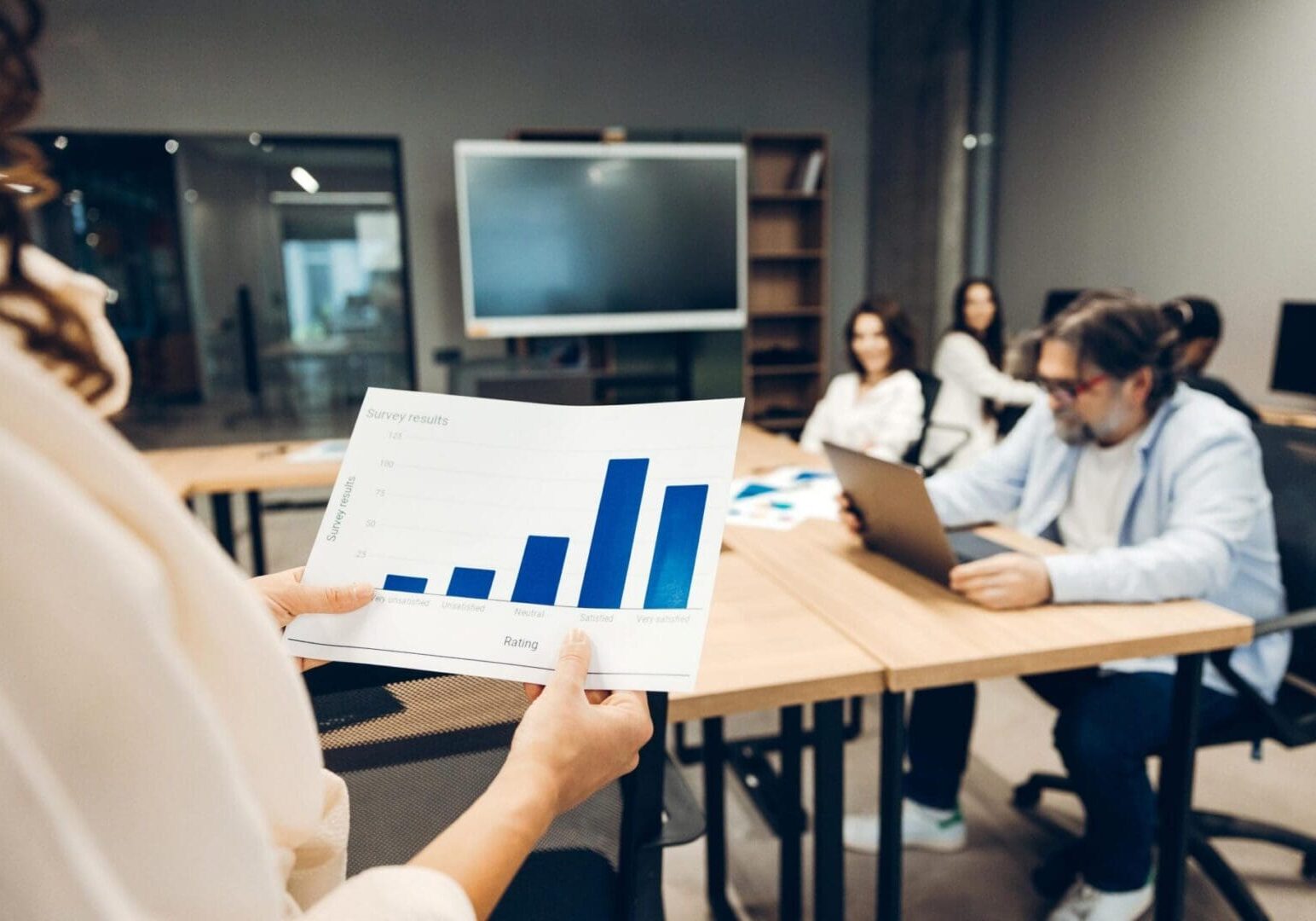 Business team members collaborating in a modern office, analyzing data and discussing charts for strategic planning and growth