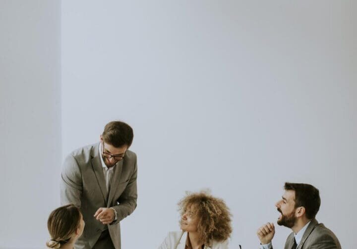 Young business people sitting at meeting table in conference room discussing work and planning strategy