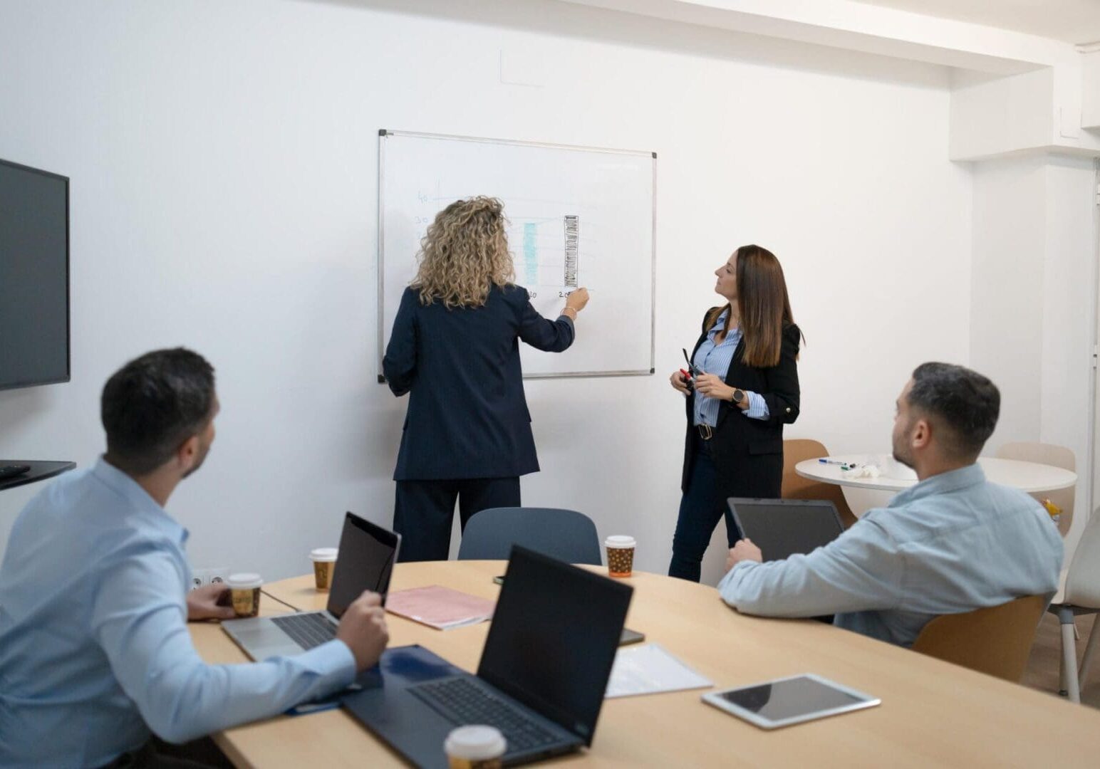 Business team collaborating and developing ideas during a corporate meeting with a whiteboard