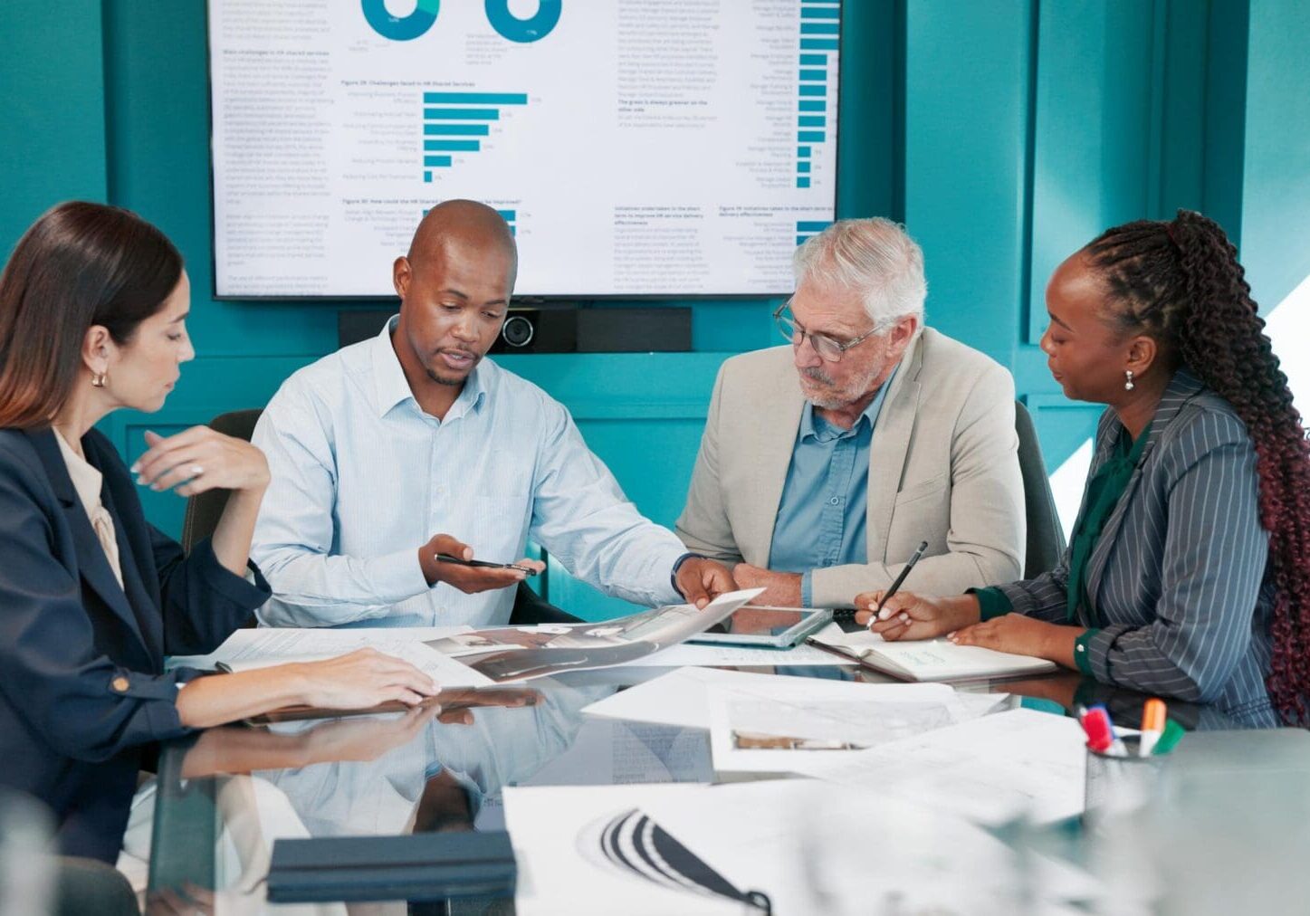 Data analysis, colleagues and discussion with paperwork in boardroom, meeting and  financial growth. Office, business analyst and people with report for performance, conversation and collaboration