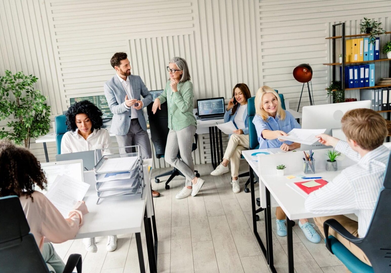 A collaborative team of professionals working together in a bright modern office environment, showcasing teamwork, communication, and a productive workplace atmosphere
