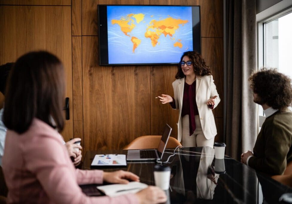 Female leader discussing worldwide business expansion and market analysis with a team during a professional conference