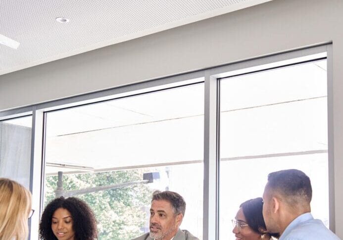 Happy busy international professional executive business team diverse colleagues employees work group talking consulting planning project, having conversation at office corporate meeting. Vertical