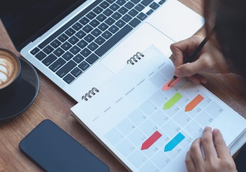 2024 Event planner timetable agenda plan on schedule event. Business woman checking planner, taking note on calendar desk on office table. Calendar event plan, work planning