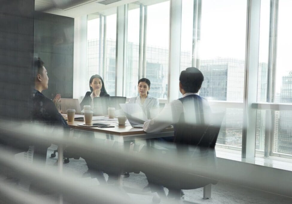 group of asian corporate executives meeting in conference room in office